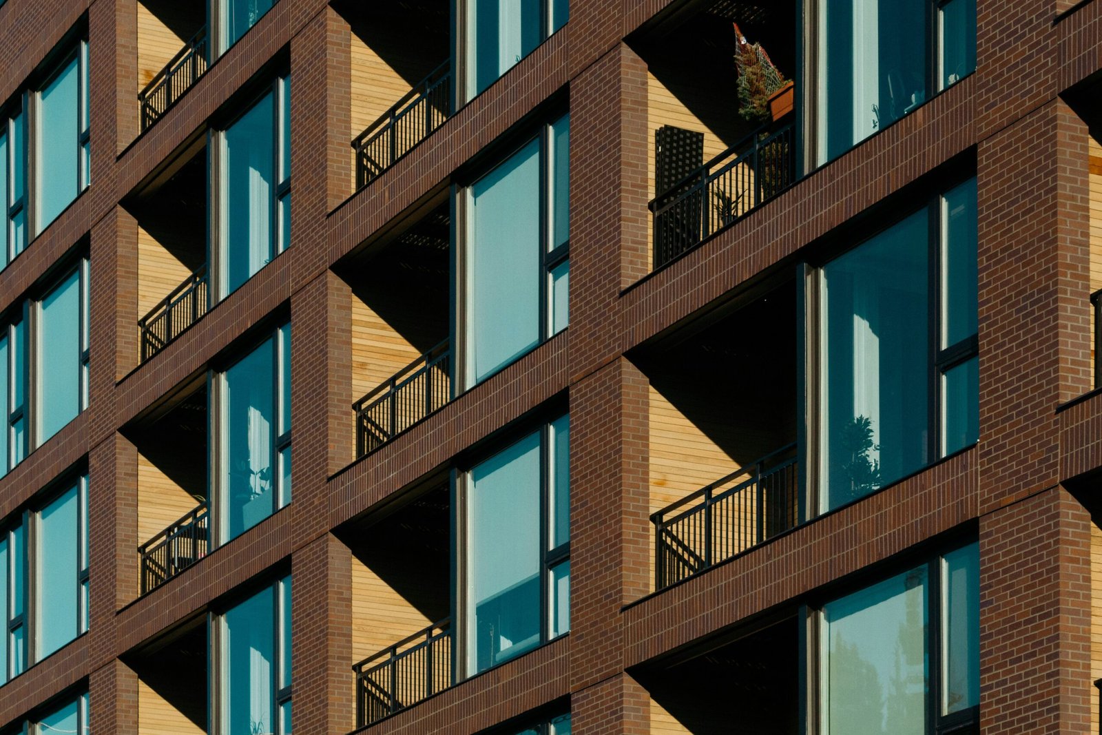 Modern apartment building in Wrocław featuring repetitive balcony and window patterns on a brick facade.