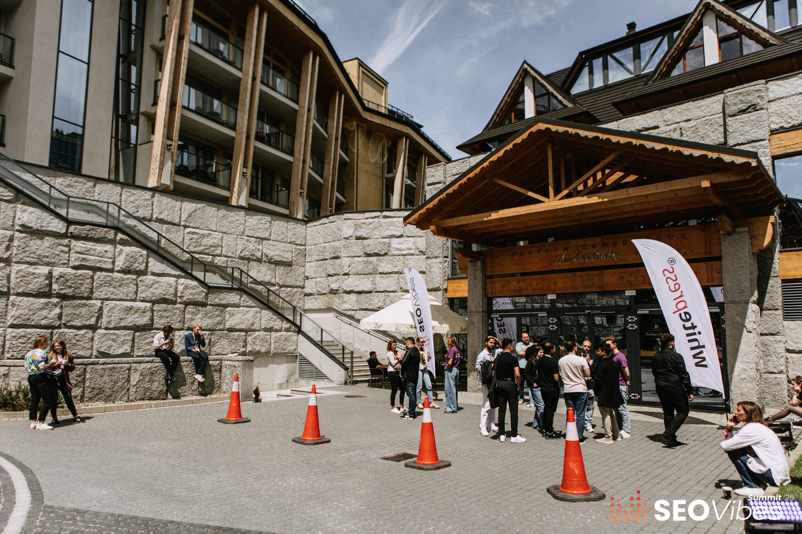 Attendees networking outside during SEO Vibes Summit 2025 in Zakopane, while sessions take place inside.