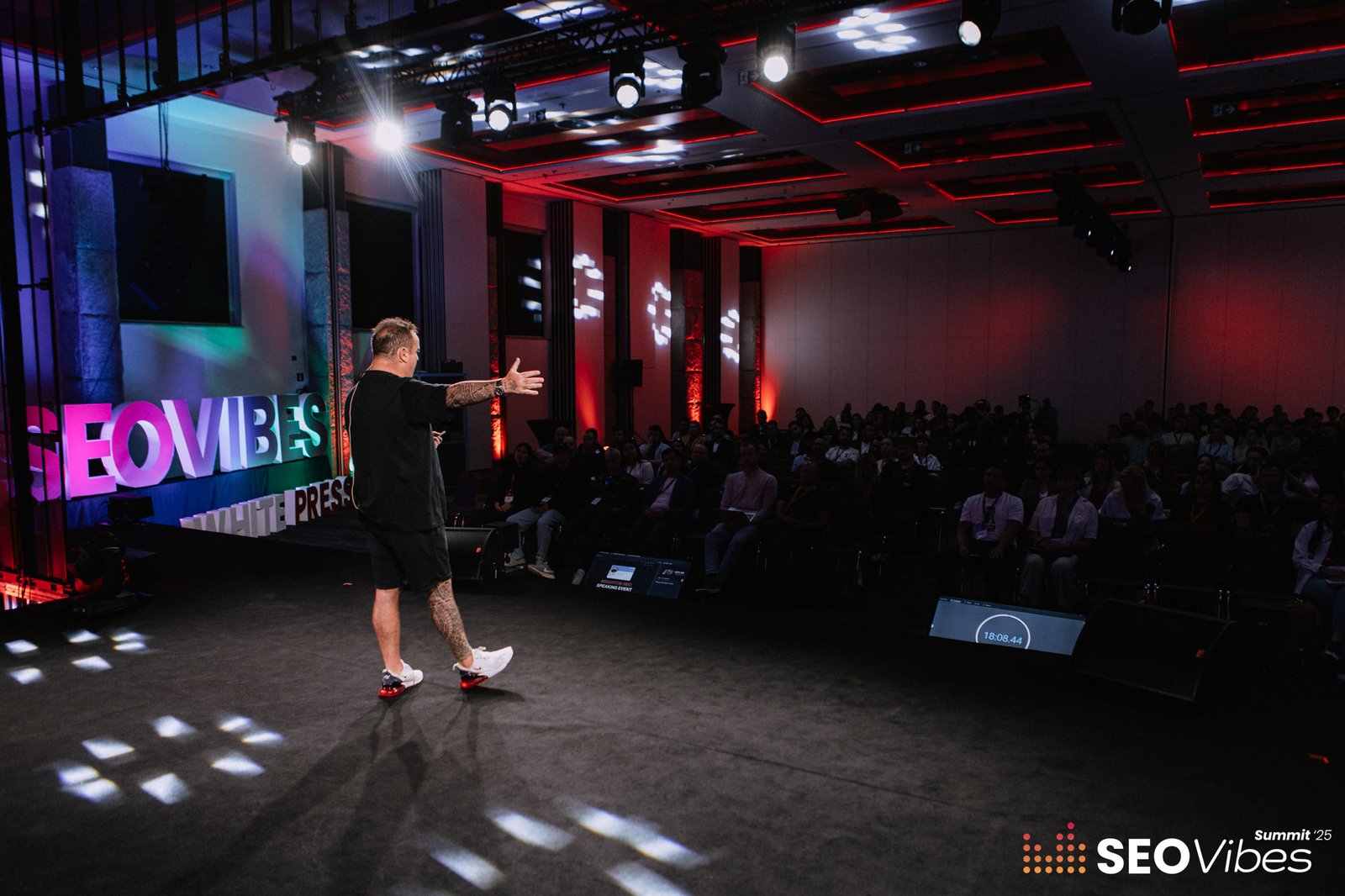 SEO expert Craig Campbell speaking on stage during the SEO Vibes Summit 2025, with a large audience attending his session in Zakopane.